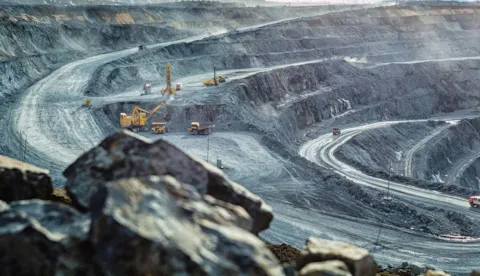Work of trucks and the excavator in an open pit on gold mining